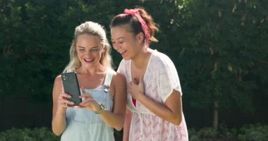 İki bayan arkadaş havuz başında güneşli bir günün tadını çıkarıyor, birlikte akıllı telefon izliyorlar. Arkadaşlık, yaz, eğlence, teknoloji, rahatlama, tatil