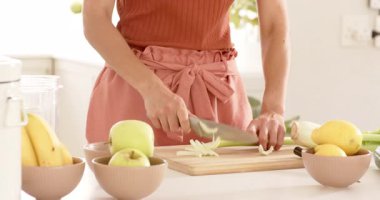 Mutfaktaki ahşap tahtada kereviz doğrayan bir kadın ve yanında taze elmalar. Aşçılık, sağlıklı, malzemeler, sebzeler, beslenme, hazırlık