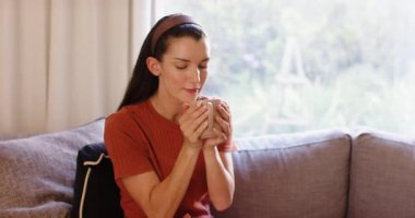 Young woman relaxing on sofa at home, enjoying peaceful afternoon indoors. Relaxation, comfortable, lifestyle, leisure, tranquility, serenity