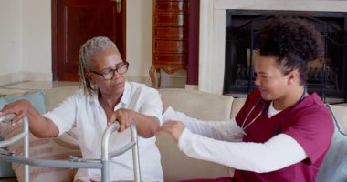 Bakıcı, yaşlı kadına evde Walker 'la yardımcı oluyor, destekleyici bakım sağlıyor. Bakım, yaşlılık, hareketlilik, yardım, sağlık, ev bakımı