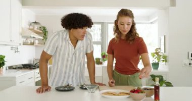 Çeşitli çiftler birlikte kahvaltı hazırlıyor, modern mutfakta taze çilek dilimliyorlar. Yemek, sağlıklı, meyve, yaşam tarzı, yemek, ev