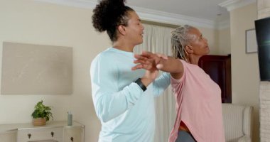 Bakıcı, evde kol egzersizleri yapan yaşlı bir kadına yardım ediyor, sağlığını arttırıyor. Yaşlılar, rehabilitasyon, sağlık hizmetleri, terapi, yardım, destek