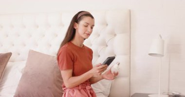 Yatak odasındaki kadın yatağın başucundaki lambayı ayarlıyor, rahatlamaya hazırlanıyor. uyku zamanı, konfor, konfor, ev, rahatlama, iç mekan