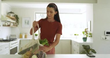 Gülümseyen kadın mutfakta yemek hazırlıyor, evde yemek pişirmekten zevk alıyor. Mutfak, yaşam tarzı, yerli, mutfak, hazırlık, mutluluk