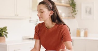 Mutfaktaki kadın kulaklıkla müzik dinlerken neşeyle dans ediyor. Yaşam tarzı, teknoloji, eğlence, mutluluk, ev, dans