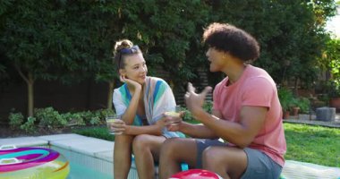 Çeşitli çiftler bilardo oynuyorlar, içki içiyorlar ve yakınlarda plaj topuyla sohbet ediyorlar. Tatil, tatil, havuz kenarı, rahatlama, yaz, arkadaşlık.