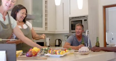 Mutfakta, kıdemli çeşitli kadınlar birlikte sebze şişi hazırlıyor, evde yemek yapmaya odaklanıyor. Sebze, takım çalışması, aşçılık, sağlıklı beslenme, hazırlık, arkadaşlık