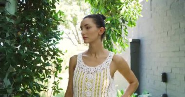 Yeşilliklerle çevrili açık havada duran tığ işi elbiseli gülen kadın. Doğa, moda, yaz, yeşillik, mutluluk, rahatlama