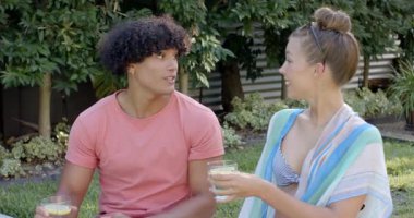 Güneşli bir günde havuz kenarında içkileri yudumlarken gülümseyen farklı çiftler. Tatil, dinlenme, dinlenme, tatil, içecekler, tropikal