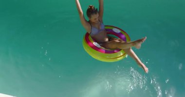 Havuzda dinlenen, renkli şişme yüzüklerde yüzen, yaz gününün tadını çıkaran, fotokopi çeken bir kadın. Rahatlama, tatil, tatil, gün ışığı, yüzme, açık hava