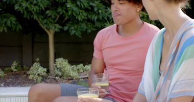 Çeşitli çiftler havuz başında rahatlıyor, sohbetin tadını çıkarıyor ve dışarıda içkileri tazeliyor. Boş zaman, tatil, rahatlama, içecekler, arkadaşlık, güneşli.