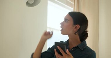 Genç bir kadın akıllı telefondan müzik dinliyor, rahat ve memnun. Yaşam tarzı, rahatlama, teknoloji, rahatlık, kulaklık, kapalı alan