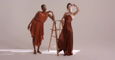 Çeşitli kadın modeller stüdyoya giriyor ve çekimler için yumuşak ışık altında merdivene yaslanıyorlar. Moda, zarafet, işbirliği, minimalizm, güzellik, profesyonellik, stüdyo