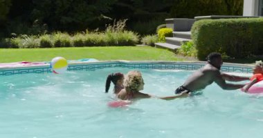 Dört kişilik çeşitli bir aile ferahlatıcı bir şeyler bulmak için havuza doğru koşuyor. Aile, eğlence, açık hava, eğlence, yaşam tarzı, hayat dolu, neşeli