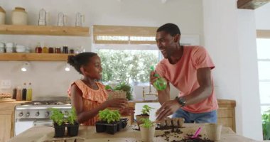 Afro-Amerikan baba ve kızı evde birlikte ot dikip kaliteli zaman geçirmenin tadını çıkarıyorlar. Çeşitli aile, bağ, bahçıvanlık, yaşam tarzı, takım çalışması, hobi