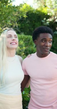 Dikey video: Güler yüzlü genç çift havuz başında güneşli bir günün tadını çıkarıyor, mutluluğu kucaklıyor. Tatil, romantizm, eğlence, açık hava, rahatlama, rahatlama