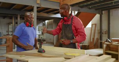 Kalem alıyor, Afrika kökenli Amerikalı akıl hocası stajyere atölyede ölçüm ve sondaj tahtası veriyor. İşçilik, akıl hocalığı, marangozluk, el işi, sanayi, işbirliği, profesyonel