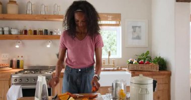 Taze meyve suyu hazırlamak, kadın mutfakta havuç dilimlemek, evde sağlığa odaklanmak. Beslenme, sağlık, yaşam tarzı, sebze, yemek pişirme, hazırlık