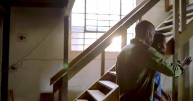 Afro-Amerikan erkek akıl hocası ve ahşap atölyesinde montaj için staj çerçevesine danışmanlık yapıyor. İşçilik, akıl hocalığı, marangozluk, marangozluk, takım çalışması, endüstriyel, tasarım