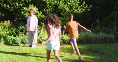 Annemi çiçekli Afro-Amerikan ailesiyle kucaklaşırken gördüm. Mor çiçekleri işaret ederek. Aileler, açık hava, doğa, sevgi, botanik, boş zaman, birliktelik.