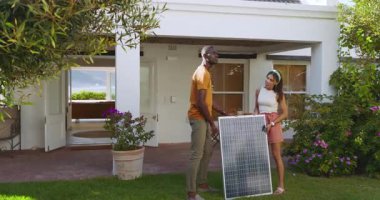 Çeşitli çiftler bahçeye güneş paneli kuruyor, sürdürülebilir yaşamın tadını çıkarıyorlar. sürdürülebilirlik, kurulum, yenilenebilir enerji, takım çalışması, çevre dostu