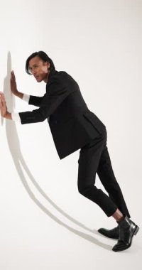 Dikey video: Şık siyah takım elbiseli Asyalı adam moda stüdyosunda güven içinde poz veriyor. zarafet, tarz, güven, fotoşop, moda, erkek giyim