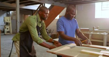 Afrika kökenli Amerikalı erkek meslektaşların kesikleri bantla işaretledikten sonra, proje için dükkânda kare şeklinde. Sanatçılık, işbirliği, hassasiyet, atölye, eğitim, iş gücü, inşaat