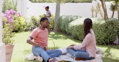 Paskalya, çeşitli aileler çimlerin üzerinde piknik yaparken çocuklar bahçede oynuyorlar. Çeşitli aile zamanları, yaz zamanı, boş zaman, bağlanma, mutluluk, çocuklar