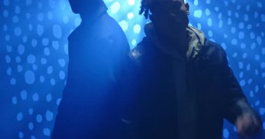 Çeşitli erkek arkadaşlar, noktalı ışık sahnesinde stüdyo çekimine hazırlanmak için ceket yakalarını çekiyorlar. İşbirliği, yoldaşlık, kentsel, karamsar, rahat, kimlik, arkadaşlık