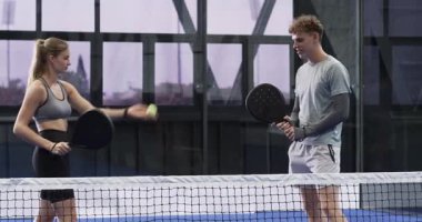 Raketleri değiş tokuş ettikten sonra, arkadaşlar forehand antrenmanı yaptılar ve kapalı sahada topla servis yaptılar. Spor, etkinlik, takım çalışması, fitness, eğlence, kentsel, modern
