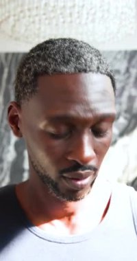 Dikey video: Cilt kremi sürmüş gülümseyen adam havuz kenarında güneşli günün tadını çıkarıyor. Sağlık, rahatlama, kendine dikkat, boş zaman, bakım, güneş ışığı.