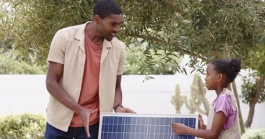 Güneş paneli, Afrikalı Amerikalı baba ve kız bahçede sürdürülebilir enerji çözümleri araştırıyor. sürdürülebilirlik, yenilenebilir, çeşitli aile, yeşil, çevre, teknoloji