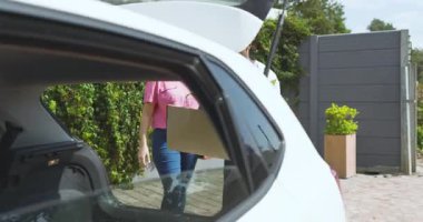 Önlüklü bir adam serada, garaj yolunda bir kadınla bahçıvanlık ipuçlarını tartışıyor. tavsiye, bahçıvanlık, sohbet, açık hava, etkileşim