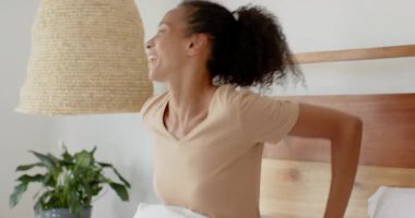 Kadın akıllı telefon kullanarak yatakta dinleniyor, evde boş vakitlerin tadını çıkarıyor. Rahatlama, yatak odası, konfor, yaşam tarzı, teknoloji