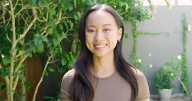 Yeşillik, bitki ve çimenlik alanda geri çekilen kamera orta yaşlı bir kadının gülümsediğini gösteriyor. Doğa, zarafet, refah, dinginlik, açık hava, yaşam tarzı, yeşillik