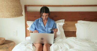 Pijamalı, yatakta dizüstü bilgisayar kullanan, evde sabah rahatlığının tadını çıkaran bir kadın. Teknoloji, eğlence, yaşam tarzı, konfor, yatak odası, dijital