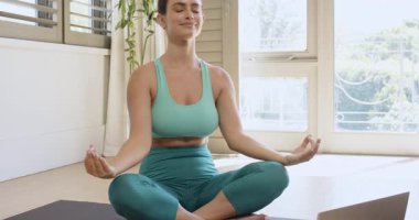 Dizüstü bilgisayardan sonra, yoga minderindeki dişi yogi kollarını kaldırıyor, sakin nefes almak için dua mudra 'sını indiriyor. Farkındalık, rahatlama, sağIık, sükunet, dinginlik, beden bilinci, meditasyon