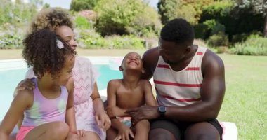 Dört çocuklu Afro-Amerikan ailesi havuz başında konuşan heyecanlı çocuğun ardından kahkahalarını paylaşıyor. Aile, açık hava, yaşam tarzı, samimi, neşeli, bağlanan, boş zaman