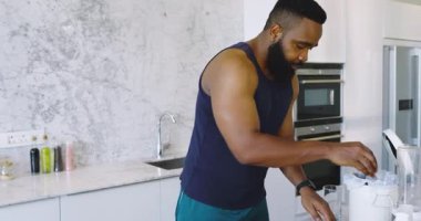 Afro-Amerikalı bir adam mermer tezgahta havuç soyuyordu, akıllı telefon gösteriyordu. Aşçılık, hazırlık, mutfak, mermer, sağlıklı, sebze, odaklanmış