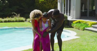 Havuz oyunundan sonra, Afrika kökenli Amerikalı aile kızı havluyla kurutuyor ve babası şamandırayı geri getiriyor. Aile, eğlence, rahatlama, açık hava, canlı, samimi, yaşam tarzı