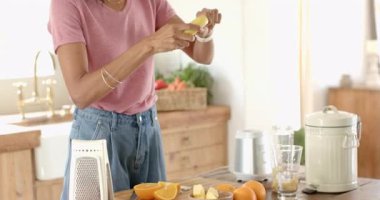 Mutfakta muz soyan bir kadın evde blender ile smoothie hazırlıyor. Yemek pişirme, beslenme, sağlıklı yaşam tarzı, uyum, sağlık, kahvaltı.