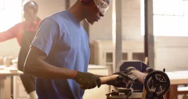 Donning gloves, Black male carpenter starting lathe, choosing chisel and shaping blank in workshop. Craftsmanship, woodworking, artisanship, toolwork, industrial, skill, creation