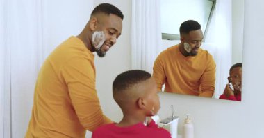Afro-Amerikalı baba ve oğul lavaboda tıraş oluyorlar. Oğullarına ilham veriyorlar. Birbirlerine bağlanmak için dişlerini fırçalıyorlar. Kaynaşma, aile, tımar, hijyen, portre, samimi, modern