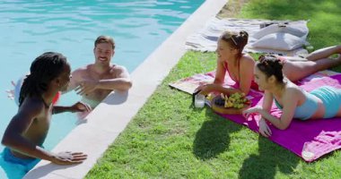 Çeşitli arkadaşlar plaj topunu havuz başına itip kakıyorlar, meyve paylaşırken yakalayıp atıyorlar. Aktivite, rahatlama, gevşeme, yaz, dostluk, canlı, açık hava