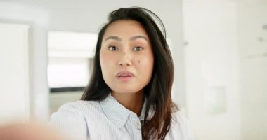 Adjusting collar Asian woman smiling and speaking to camera at home and sharing sincere message. Authenticity, communication, confidence, casual, lifestyle, technology, expression