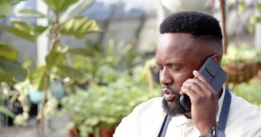 Bahçıvan önlüklü, seradaki çocuk masasında deftere notlar yazıyor. Bahçıvanlık, bahçıvanlık, bitkiler, notlar, yeşillik.