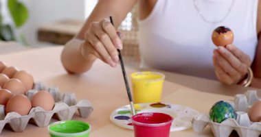 Anne ve kızı Paskalya yumurtalarını boyuyor, bağ kuruyor ve birlikte gülüyorlar, bahçede. Çeşitli aile, yaratıcılık, gelenek, bayram, yumurta dekorasyonu, şenlik