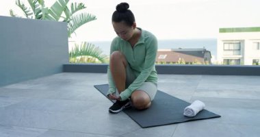 Çatı terasına varmak, yoga minderini açmak, ayakkabı bağlamak ve egzersiz için bacaklarını esnetmek. Fitness, outdoor, wellness, sükunet, egzersiz, rahatlama, manzara