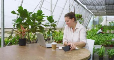 Serada, dizüstü bilgisayarla konuşan ve not alan bir kadın. Teknoloji, çoklu görev, üretkenlik, iş, iletişim, tarım