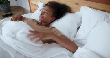 Kadın yatakta uyanıyor, esniyor ve evde rahat görünüyor. Sabah, rutin, rahatlama, uyanma, rahat, yaşam tarzı